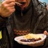 Ein Obdachloser isst das von der Organisation Kältebus München e.V. ausgegebene Essen in München.