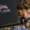 Eine Frau hält ihren Sohn im Arm, während sie ihren Stimmzettel in einem Wahllokal im South Valley von Albuquerque ausfüllt. 