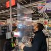 Eine Plexiglasscheibe wird in Dresden an einem Supermarkt angebracht. Kunden und Mitarbeiter sollen so vor dem neuartigen Coronavirus geschützt werden.