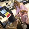 Die kleine Mia unterstützt Mama Nadine Meidinger beim Einkauf und scannt die Waren an der SB-Kasse.                    