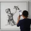 Eine medizinische Mitarbeiterin fotografiert das erst kürzlich erschienene Banksy-Kunstwerk mit dem Titel "Game Changer".