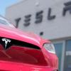 Ein Model X von Tesla steht vor einem Tesla-Händler.