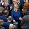 Bundeskanzlerin Angela Merkel gibt bei der Sitzung des Bundestages ihre Stimmkarte bei der namentlichen Abstimmung über neue Organspende-Regeln ab.