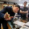 TY Lee, Besitzer eines Schreibwarenladens in Taipeh Taiwan, zeigt, wie ein Stift zum Schönschreiben richtig gehalten wird.