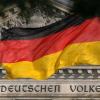 Die Deutschland-Fahne weht vor dem Reichstag in Berlin, auf dem der Spruch "Dem deutschen Volke" zu lesen ist.