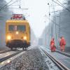 Arbeiter der Bahn reparieren eine durch einen umgestürzten Baum beschädigte Oberleitung.