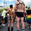 Den sommerlichen Temperaturen angepasst trägt ein Teilnehmer der CSD-Parade nur einen Gürtel und sein Smartphone bei sich.