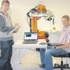 Das Bild zeigt zwei angehende Mechatronik-Techniker der Fritz-Hopf-Technikerschule bei der Roboter-Programmierung im TCW.  