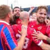 Die Spieler von Energie Cottbus bejubeln nach Schlusspfiff und Platzsturm den Aufstieg mit den Fans.