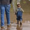 Ein Kind spaziert im Koblenzer Stadtteil Güls mit Gummistiefeln durch das Hochwasser.