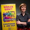 Katarina Niewiedzial, Beauftragte für, Migration der Stadt Berlin, steht vor einem Plakat der Kampagne zur Europawahl 2024.