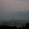 Regen fällt aus dichten Regenwolken über den Bergen und auf das Alpenvorland.