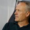 Freiburgs Trainer Christian Streich sitzt auf der Bank.