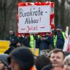 Ein Landwirt hält während der Kundgebung vor dem Brandenburger Tor ein Schild mit der Aufschrift «Bürokratie-Abbau! Jetzt» hoch.