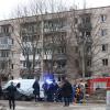 Menschen beobachten, wie Rettungskräfte nach einer Explosion an der Seite des beschädigten Wohnhauses in Sankt Petersburg arbeiten.