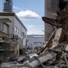 Trümmerteile liegen nach einem Großbrand vor einem zum Teil zerstörten Gebäude auf dem Gelände einer Firma für Metalltechnik in Berlin-Lichterfelde.