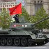 Ein sowjetischer T-34-Panzer mit roter Flagge rollt während der Militärparade zum Tag des Sieges in Moskau.