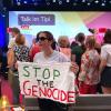 "Stop the Genocide" steht auf einem Transparent, dass eine Frau während einer Veranstaltung mit Außenministerin Baerbock im Rahmen der Demokratiefestets anlässlich des Jubiläums 75 Jahre Grundgesetz hält.