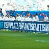 Hoffenheims Spieler halten vor Beginn des Spiels ein Transparent mit der Aufschrift „Nie wieder. Kein Platz für Antisemitismus“.