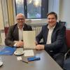 Minister Fabian Mehring (links) hat Landrat Markus Müller für die Digitalisierung des Dillinger Landratsamts einen Förderscheck in Höhe von 20.000 Euro übergeben. 