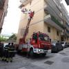 Von einem Hubwagen aus inspiziert ein Feuerwehrmann am Dienstag in Pozzuoli die Schäden an einem Gebäude.