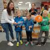 Carina Freudling (von links) und Hildegard Häfele erklärten den Grundschülern Philipp, Paula und Oliver, alle sieben Jahre alt, den Laufzettel "Checker Osterhase" für die erste Osterschnitzeljagd der Stadtbücherei.