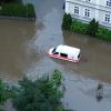 Ein Krankenwagen fährt über eine überschwemmte Straße in Schrobenhausen im Landkreis Neuburg-Schrobenhausen.