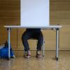 Ein Mann sitzt während der Europawahl in einer Wahlkabine, um seinen Wahlzettel auszufüllen.