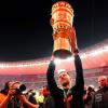 Leverkusens Trainer Xabi Alonso jubelt nach dem Sieg mit der Siegestrophäe. 
