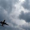 Gewitterwolken türmen sich über einem Flugzeug auf.