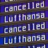 Anzeigentafeln zeigen «cancelled» und «Lufthansa» am Flughafen München an.