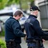 Beamten der Berliner Polizei stehen vor einem Haus an der Königsallee.