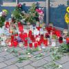 Blumen und Trauerkerzen stehen vor einem Kaufhaus und erinnern an die 30 Jahre alte Frau, die hier getötet wurde.