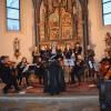 Im Vordergrund ist Solistin Annika Hausmann zu sehen - gemeinsam mit dem Ensemble „Musica fiorente“ der Pfarrei St. Martin Lauingen und Sängerinnen und Sänger des Gesangsstudios Miriam Galonska. 