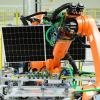 Ein Solarmodul wird mit einem Roboter zum nächsten Arbeitsgang transportiert.