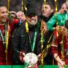 Jürgen Klopp (M) jubelt mit dem Pokal.