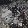 Palästinenser betrachten die Überreste von einem Wohnhaus, das bei einem israelischen Angriff im Gazastreifen zerstört wurde.  
