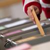 Eine Wählerin wirft in einem Wahlraum im Rathaus im Sigmaringer Stadtteil Laiz einen Wahlschein in eine Urne.