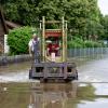 Mit allen Mitteln: Helfer fahren mit einem Gabelstapler über eine überflutete Straße in Reichertshofen.