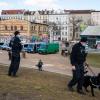 Zwei Polizisten und ein Polizeihund stehen bei einem Polizeieinsatz im Görlitzer Park.