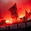Fans von Bayern München schwenken Fahnen und brennen Pyrotechnik ab.