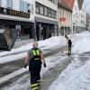 Einsatzkräfte der Feuerwehr räumen Hagel von einer Straße. Winterdienst-Einsatz mitten im Sommer 2023: Ein lokal begrenztes Unwetter hat Straßen in der Innenstadt von Reutlingen mit einer hohen Hagel-Schicht überzogen.