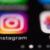 Das Logo des Fotonetzwerks Instagram (l) ist auf dem Bildschirm eines iPhones zu sehen.