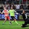 Regensburgs Dominik Kother (l) trifft im Jahnstadion Regensburg gegen Wiesbadens Torwart Florian Stritzel (r) zum 2:2.