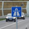 Ein blau-weisses Schild weist auf den Beginn der Autobahn hin.