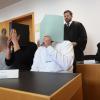 Der Hauptangeklagte (vorne r) sitzt in einem Gerichtssaal neben weiteren Angeklagten auf der Anklagebank.