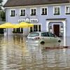 In Günzburg müssen Menschen aus Häusern gerettet werden, bevor weitere Wassermassen kommen. Der Verkehr wird von Polizei und Einsatzkräften geregelt.