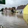 In Günzburg müssen Menschen aus Häusern gerettet werden, bevor weitere Wassermassen kommen. Der Verkehr wird von Polizei und Einsatzkräften geregelt.