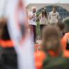 Die Angeklagten Edmund Schultz (hinten, l-r), Mirjam Herrmann, und Henning Jeschke stehen bei einer Demonstration auf der Bühne.