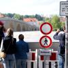 Menschen schauen sich in der Altstadt am Donauufer hinter einer Schutzwand das Hochwasser an.